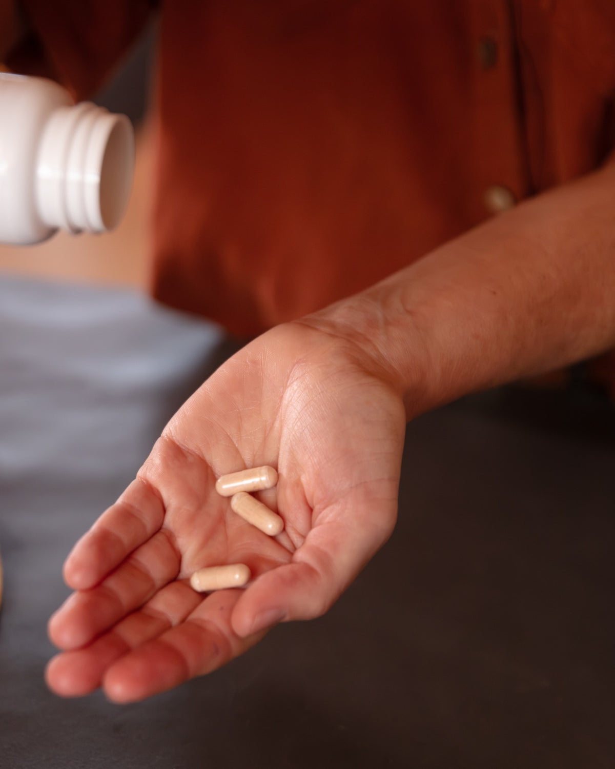 Three capsules in an open hand